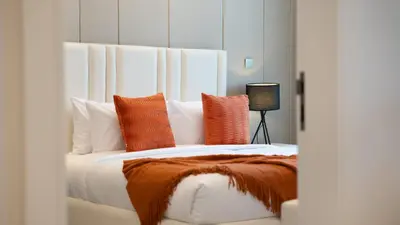 a bedroom with a large bed with orange and white pillows at Luxury Comfort 1BRNear Dubai Mall & Burj Khalifa in Dubai