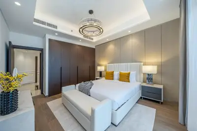 a bedroom with a white bed and a couch at Sky-High 2BR Escape Stylish Stay Near Dubai Mall in Dubai