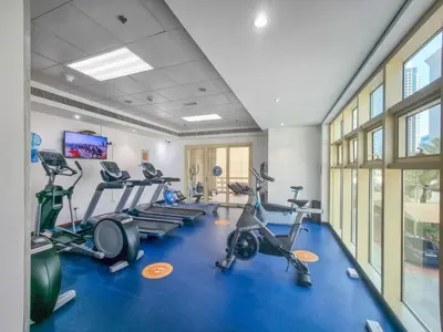 a gym with treadmills and elliptical machines at Royal Oceanic Elegant 2BR with Marina View in Dubai