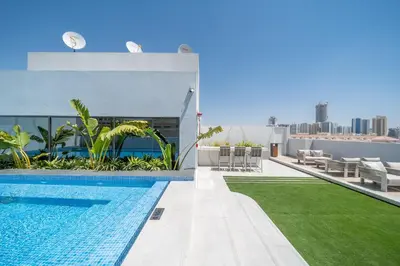 a swimming pool on the roof of a house with a lawn at Luxurious Design Boutique Studio Hideaway JVC in Dubai