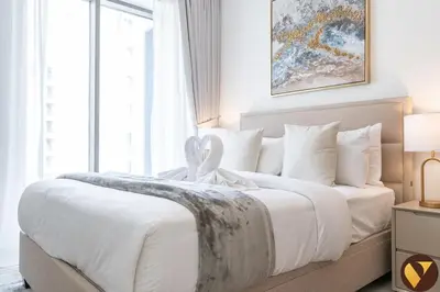 a bedroom with a large bed with white sheets at Vogue Creek Beach Rosewater Waterfront Living close to Downtown, Burj Khalifa and Dubai mall, Two Bedroom Apartment with Balcony and Vibrant Community View, Private Manmade Beach, Access to all Amenities in Sabkhah