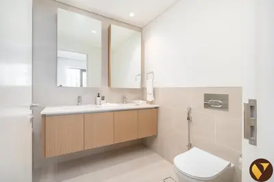 a bathroom with a toilet and a sink and a mirror at Vogue Creek Beach Rosewater Waterfront Living close to Downtown, Burj Khalifa and Dubai mall, Two Bedroom Apartment with Balcony and Vibrant Community View, Private Manmade Beach, Access to all Amenities in Sabkhah