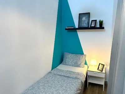 a room with a bed and a small table with a lamp at delightful Partition Room Barsha Heights Tecom in Dubai