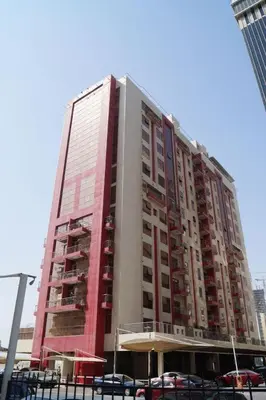 a tall building with cars parked in front of it at Pleasing Partition Room Barsha Heights tecom in Dubai