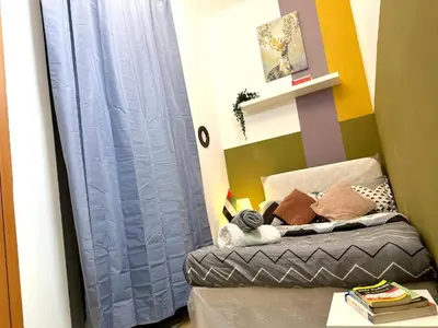 a bedroom with a bed with a blue curtain at Pleasing Partition Room Barsha Heights tecom in Dubai