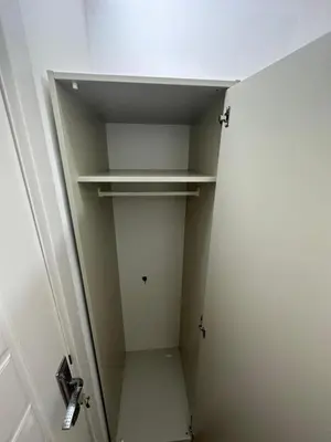 a small walk in closet with a white door at Nice Looking Partition Room Barsha Heights Tecom in Dubai