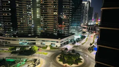 a view of a city at night with buildings at Nice Looking Partition Room Barsha Heights Tecom in Dubai