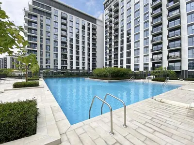 a large swimming pool in front of two tall buildings at DAYF-PAR Large 3 Bed with Full Skyline View in Dubai Hills in Dubai