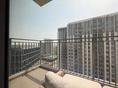 a balcony with a couch and two tall buildings at DAYF-PAR Large 3 Bed with Full Skyline View in Dubai Hills in Dubai