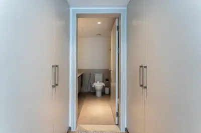 a bathroom with a toilet and a hallway with doors at DAYF-PAR Large 3 Bed with Full Skyline View in Dubai Hills in Dubai