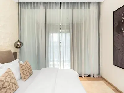 a bedroom with a white bed and a large window at Brand New Luxury Duplex in 5 Star JVC Development in Dubai