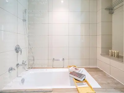 a bathroom with a bath tub with a shower at Luxurious paramount 2BR with Pool,Gym, Sauna & Bar 10 mins to Burj Khalifa in Dubai
