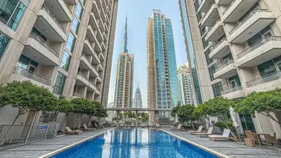 a swimming pool in a city with tall buildings at Chic Studio Apartment, Pool and Balcony, Steps to Burj Khalifa in Dubai