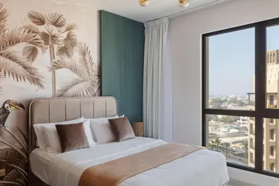 a bedroom with a large bed with a large window at Spacious 1BD, City View, Pool & Beach access in Dubai