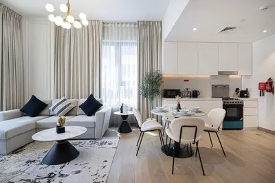 a living room with a couch and a table and chairs at Stylish Apartment - Private Beach - Port de La Mer in Dubai