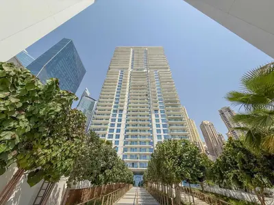 a tall building with trees in front of it at Jumeirah Beach Residences Private Beach & Sea View in Dubai