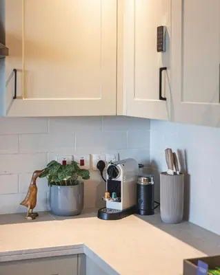a kitchen counter with white cabinets and a plant at The Burj View Suite Luxury 1BR Full Burj Views in Dubai