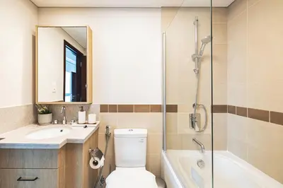 a bathroom with a toilet and a sink and a shower at The Burj View Suite Luxury 1BR Full Burj Views in Dubai
