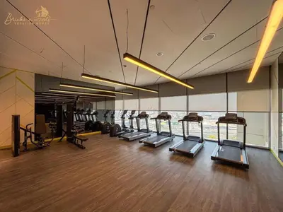 a gym with a row of treadmills in a building at Serene Canal View 2Bhk 6 pax in Dubai