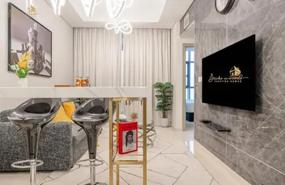 a living room with a bar with stools and a tv at Serene Canal View 2Bhk 6 pax in Dubai