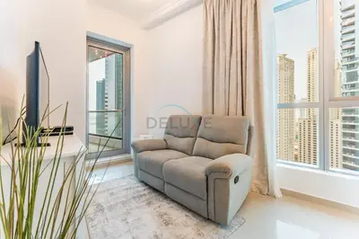 a living room with a chair and a large window at Short Walk to Marina Mall, Marina Walk and JBR Beach, Stunning Marina Views - Bay Central 2, Dubai Marina by Deluxe Holiday Homes in Dubai