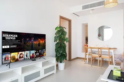 a living room with a large flat screen tv on a wall at Vida Yacht Club Marina 2BDR Sky Suite in Dubai