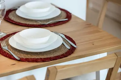 a table with two white plates and silverware on it at Vida Yacht Club Marina 2BDR Sky Suite in Dubai