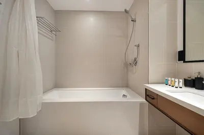 a white bathroom with a tub and a sink at Vida Yacht Club Marina 2BDR Sky Suite in Dubai