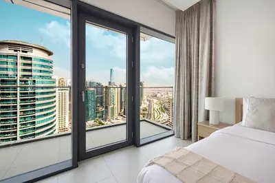a bedroom with a bed and a large window at Vida Yacht Club Marina 2BDR Sky Suite in Dubai