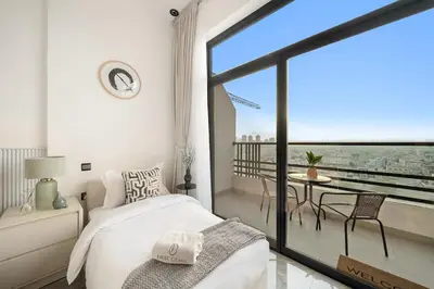 a bedroom with a bed and a balcony with a view at Dubai Arjan Studio - Near Miracle Garden, Hills Mall & Attractions in Dubai
