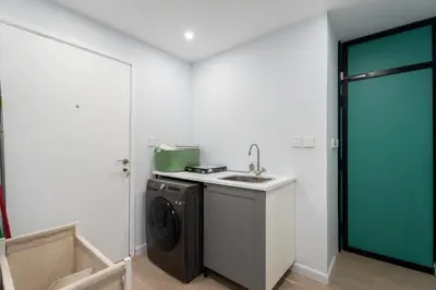 a bathroom with a sink and a washing machine at High-End Designer Stay l 4 Bed + Maids Room l JBR in Dubai