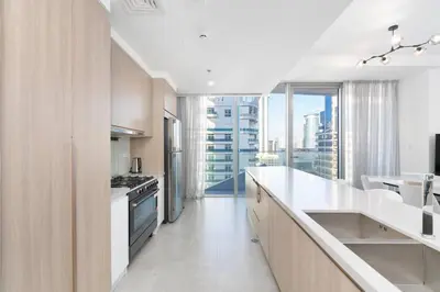 a kitchen with white counters and a large window at Elegant Living in the Heart of Dubai Marina in Dubai