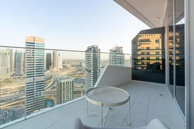 a table and chair on a balcony with a view at Elegant Living in the Heart of Dubai Marina in Dubai