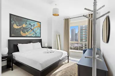 a bedroom with a bed and a large window at Sleek and Spacious 2BR at Dubai Marina, Near Beach in Dubai