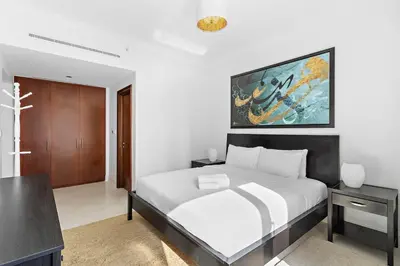 a bedroom with a bed and a painting on the wall at Sleek and Spacious 2BR at Dubai Marina, Near Beach in Dubai