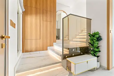 a hallway with stairs with a mirror and a stool at 3BR Luxury Townhouse with Garden in Dubai
