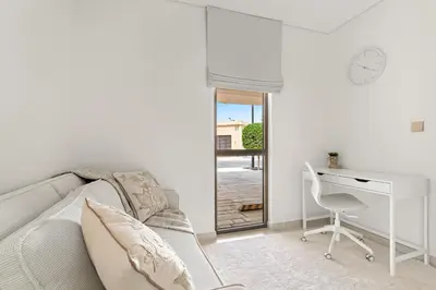 a white living room with a desk and a couch at 3BR Luxury Townhouse with Garden in Dubai