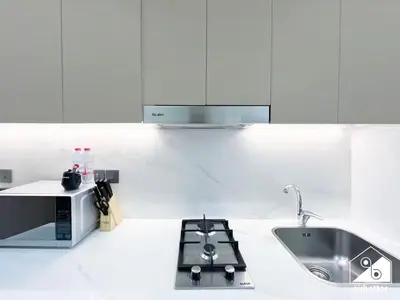 a white kitchen with a sink and a microwave at Serenity Studio with Balcony at Azizi Riviera in Dubai