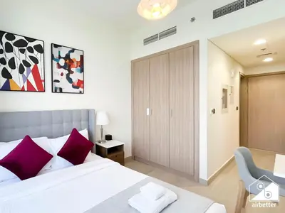 a bedroom with a large bed with purple pillows at Modern Comfort Studio Relax & Unwind in Style in Dubai