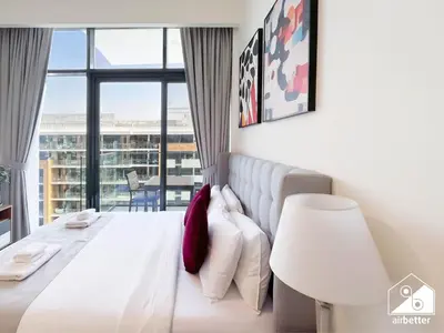 a bedroom with a white bed and a large window at Modern Comfort Studio Relax & Unwind in Style in Dubai