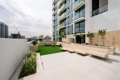 an apartment patio with benches and a lawn at Citylight 1br Escape Gym, Pool And Free Parking! in Dubai