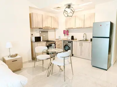 a kitchen with a table and chairs and a refrigerator at SUPERIOR STAY High Floor, Stylish Studio in Business Bay in Dubai