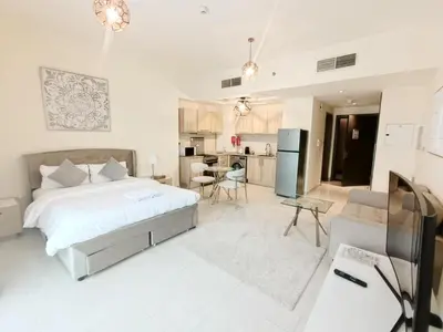 a white bedroom with a bed and a kitchen at SUPERIOR STAY High Floor, Stylish Studio in Business Bay in Dubai