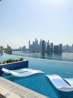 a swimming pool with a city skyline in the background at GuestReady – Infinity Pool and Beach l Palm in Dubai