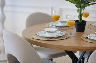 a wooden table with chairs and glasses of orange juice at Unreal Patio Private beach Sea View 1BR in Dubai