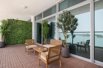 a balcony with chairs and a table and some plants at Unreal Patio Private beach Sea View 1BR in Dubai
