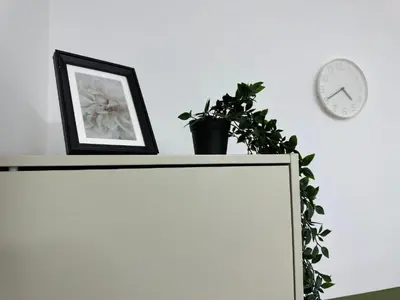 a white cabinet with a picture and a plant on it at Tourist Partition Room Barsha Heights Tecom in Dubai