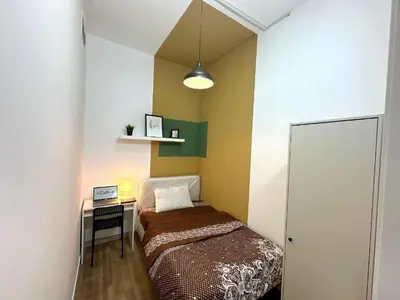 a small bedroom with a bed and a desk at Charming Partition Room Barsha Heights Tecom in Dubai