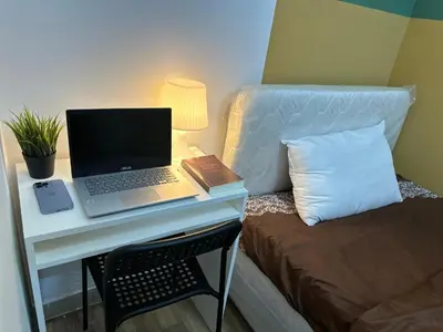 a desk with a laptop computer on it next to a bed at Charming Partition Room Barsha Heights Tecom in Dubai
