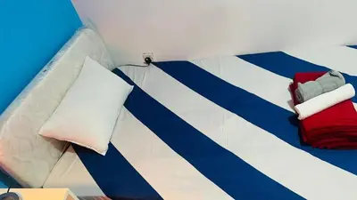 a room with a bed with blue and white stripes at Divine Partition Room Barsha Heights Tecom in Dubai